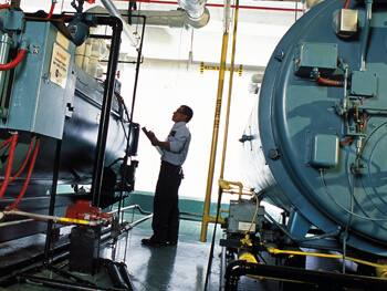 Technician providing boiler maintenance at a client facility